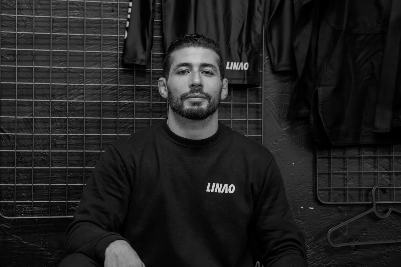 Achraf Elhazime, en sweat LINAO, assis devant les kimonos du club