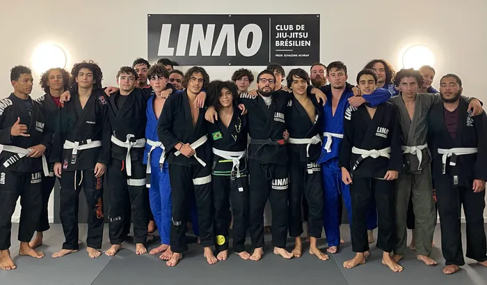 Les élèves du LINAO Club en kimono devant le mur du club