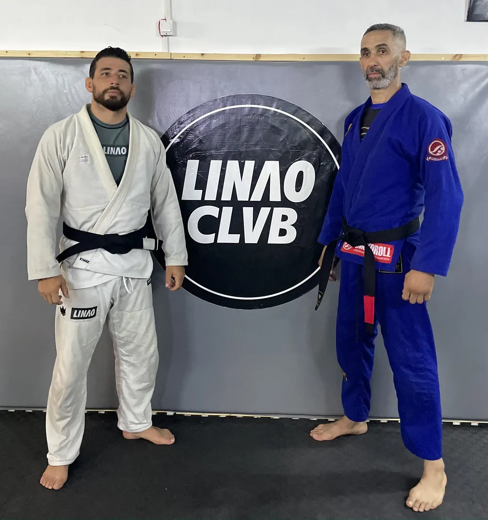 Deux pratiquants en kimono blanc et bleu devant le logo LINAO Club
